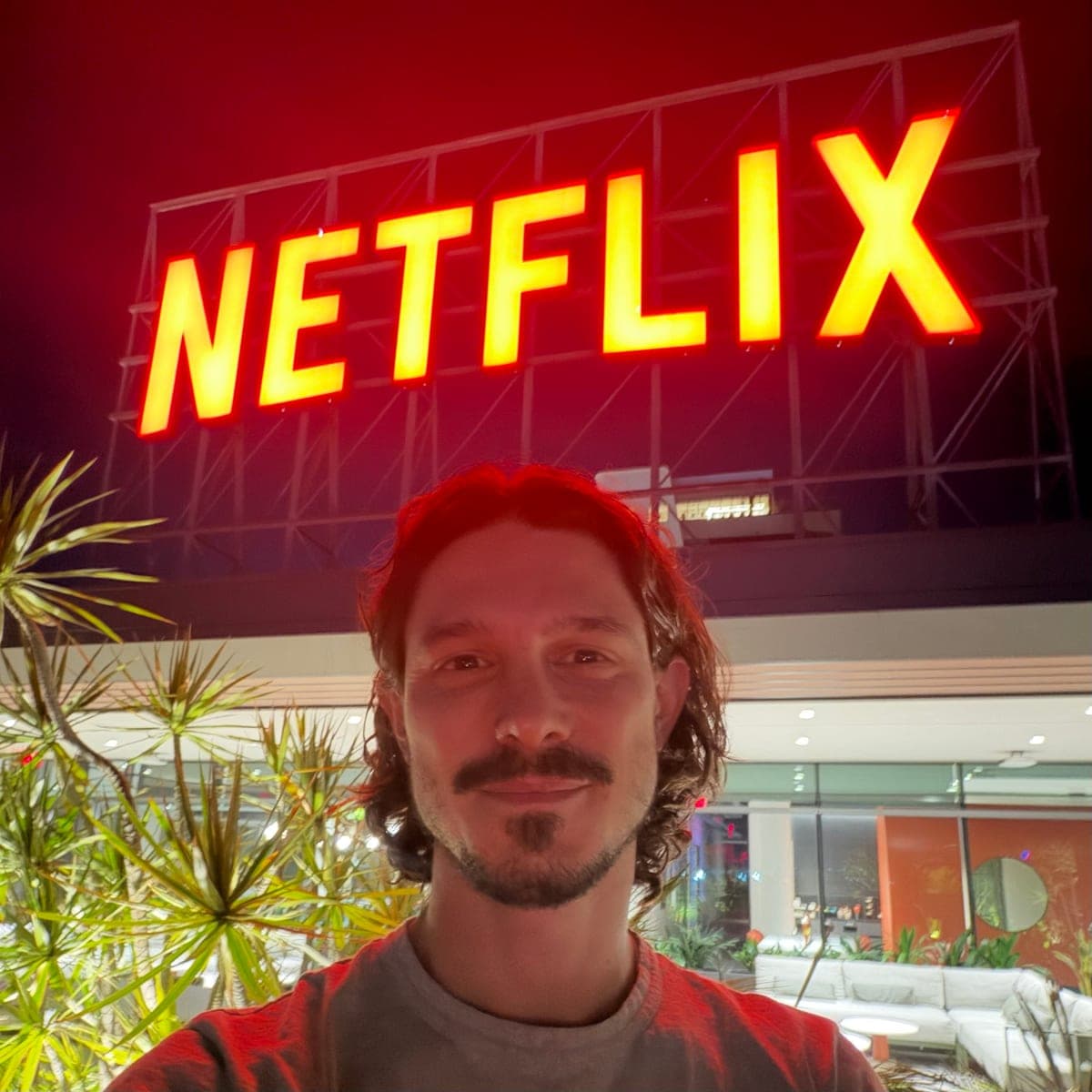 Joshua outside the Netflix offices in Los Angeles at night, under the lit-up Netflix sign
